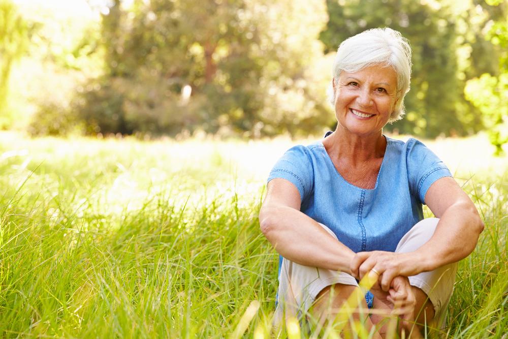 Older white woman in field of grass smiling, centerville oh