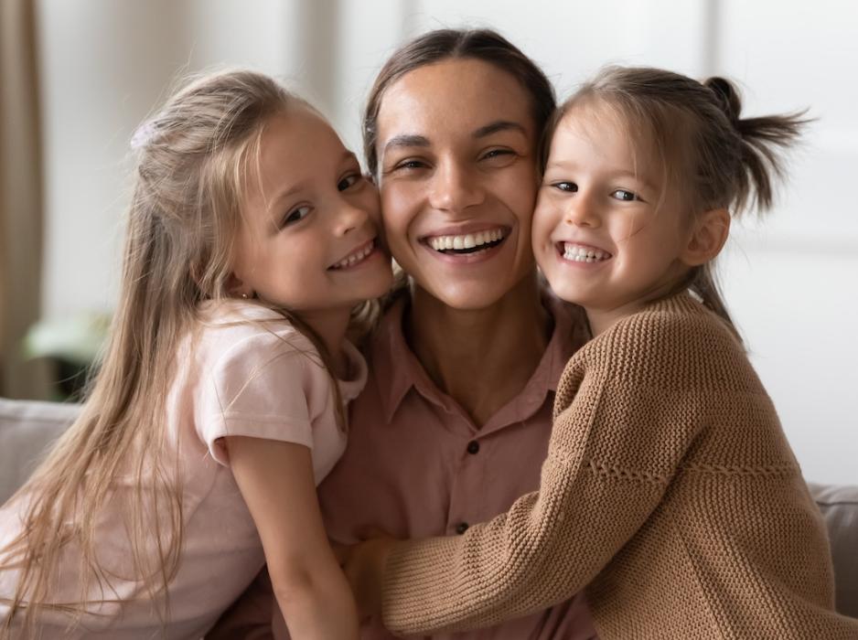 Mom smiling with two young girls smiling, centerville oh
