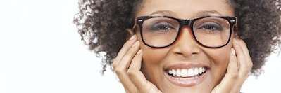 Black woman with glasses smiling after holistic dentistry treatment, centerville oh