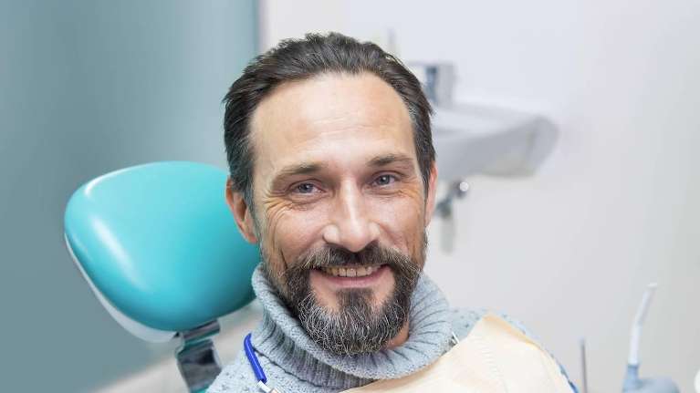 Middle aged man smiling in dentist chair, centerville oh
